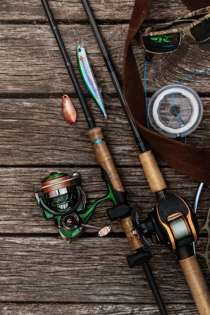 Fishing rods, reels and lures laid out on weathered wood