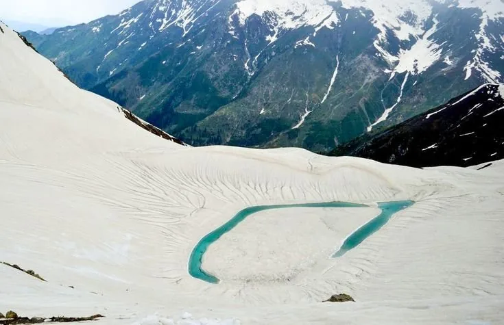 The teardrop of Ansoo Lake set in high snowfields